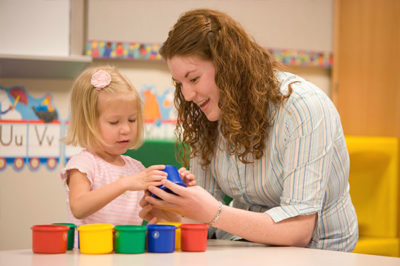 Education student working with little girl.