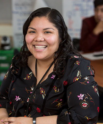 Female alumni teacher smiling.