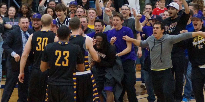 Basketball team celebrating with fans.