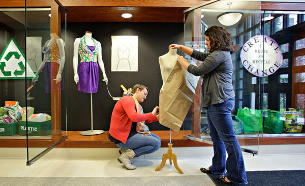 Fashion merchandising students working on display.