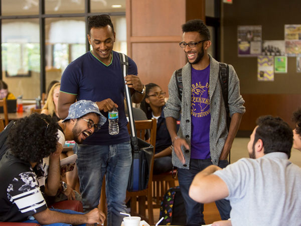 Group of male students laughing at lunch.