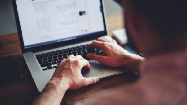 Closeup of hands working on a laptop computer.