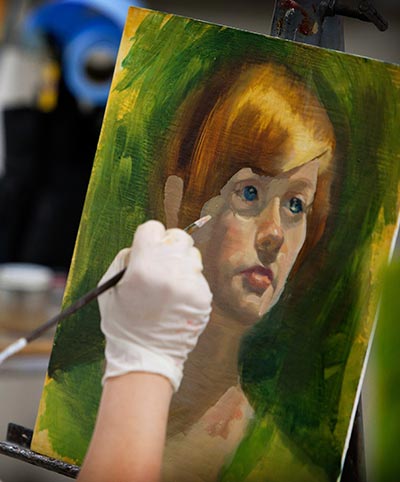 Closeup of a student in painting class.